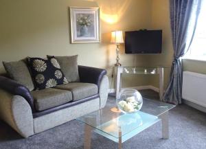a living room with a couch and a glass table at Mary Naoise Holiday Home in Lettermacaward