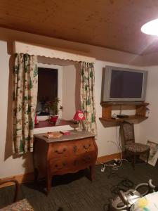 a living room with a television and a wooden table at Les PLAGNES in Vailly