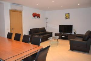 a living room with a table and leather furniture at Moradia Fantástica com Piscina a 5 min da Praia in Monte Gordo