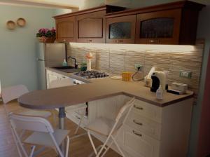 a kitchen with a counter with a table and chairs at La Casina in Salaiola