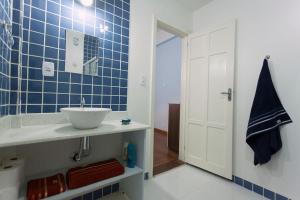 baño con lavabo y pared de azulejos azules en Casa Saga - All Suites en Río de Janeiro