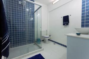 Casa Saga - All Suites في ريو دي جانيرو: حمام مع دش زجاجي ومرحاض