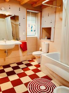 Ein Badezimmer mit Schachbrettmusterboden, Toilette und Waschbecken in der Unterkunft O Recanto do Atlantico in Viveiro + 31 Fotos