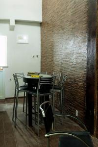 uma mesa e cadeiras num quarto com uma parede de tijolos em Casa Saga - All Suites no Rio de Janeiro