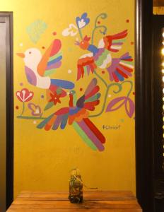 a painting on a wall with colorful flowers at Hostal La 59 in Mérida