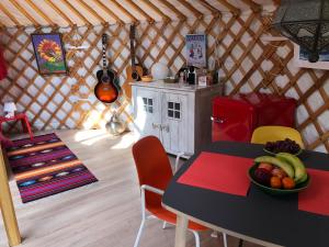a room with a table and chairs in a yurt at Overnachten in een luxe yurt! in Zonnemaire