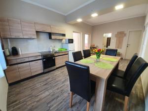 a kitchen with a wooden table and chairs in a kitchen at Flamingo Apartment in Sárvár