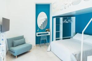 - une chambre avec un lit, une chaise et un bureau dans l'établissement AuroRooms Affittacamere, à Scoglitti