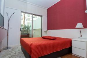 a red bedroom with a bed with a red wall at Praia da Rocha Edifício Foz Palace t2 in Portimão +17 photos