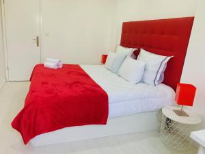 a bedroom with a large bed with a red blanket at Entire apartment in Lisbon plus Car in Lisbon