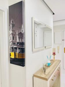 a bathroom with a picture of a yellow streetcar on the wall at Entire apartment in Lisbon plus Car in Lisbon