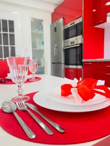 a red and white kitchen with a plate and silverware at Entire apartment in Lisbon plus Car in Lisbon