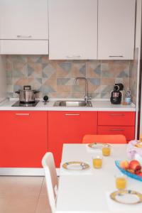 una cucina con armadi rossi e un tavolo con un cesto di frutta di 068 - Casa STELLA MARINA in CENTRO, 450metri da Mare e Spiaggia a Sestri Levante
