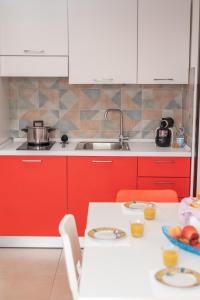 a kitchen with red cabinets and a table with a bowl of fruit at 068 - Casa STELLA MARINA in CENTRO, 450metri da Mare e Spiaggia in Sestri Levante