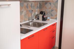 una cucina con armadi rossi e lavandino di 068 - Casa STELLA MARINA in CENTRO, 450metri da Mare e Spiaggia a Sestri Levante