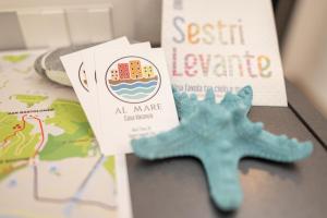 een blauwe zeester naast een boek en een kaart bij 068 - Casa STELLA MARINA in CENTRO, 450metri da Mare e Spiaggia in Sestri Levante