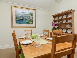 uma sala de jantar com uma mesa de madeira e cadeiras em Seabien em Falmouth