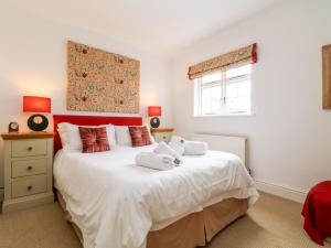 um quarto com uma grande cama branca com toalhas em Seabien em Falmouth