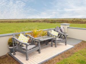 a patio with two chairs and a table on a deck at Sea View Lodge in Mullagh