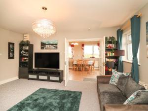 a living room with a couch and a flat screen tv at Sea View Lodge in Mullagh