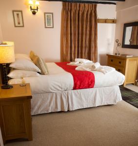a bedroom with two beds and a table and a window at Burnthwaite Cottage in Windermere