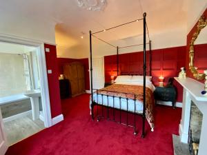 ein Schlafzimmer mit einem Himmelbett mit roten Wänden in der Unterkunft Blenheim Guest House in York
