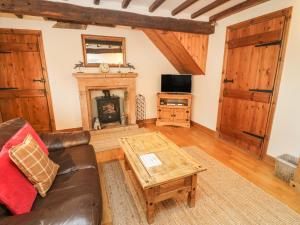 a living room with a couch and a fireplace at Clove Cottage in Great Ormside