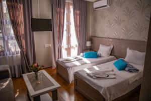 um quarto de hotel com duas camas e uma mesa em Family Hotel Kolorit Old Tbilisi em Tbilisi