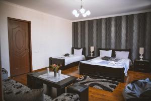 Sala de estar con 2 camas y mesa en Family Hotel Kolorit Old Tbilisi en Tiflis