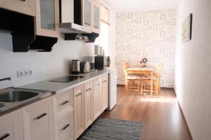 una cocina con armarios blancos y una mesa con una silla en Downtown Apartment, en Pärnu