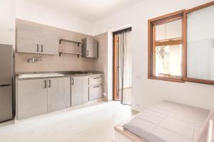a kitchen with white cabinets and a window at Villaggio Camping Oasi in Vieste