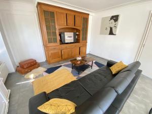 ein Wohnzimmer mit einem schwarzen Sofa und einem Tisch in der Unterkunft The 5 Continents II by Stay Swiss in Pruntrut
