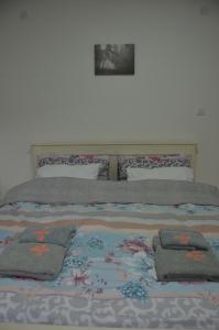 Una cama con tres almohadas encima. en Apartman Rajak, en Vrnjačka Banja