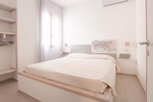 a bedroom with a white bed in a white room at Villaggio Camping Oasi in Vieste