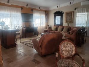 a living room with a couch and a piano at Maria's Place, Puerto Peñasco, Oriente in Puerto Peñasco
