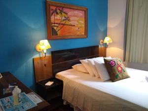 Un dormitorio con una cama con dos lámparas y una mesa. en Pousada Vila Inconfidentes - Centro Historico, en Tiradentes