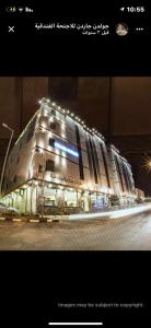 ein großes Gebäude wird nachts beleuchtet in der Unterkunft Golden Garden Hotel Suites in Riad