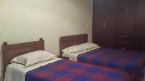 een slaapkamer met 2 bedden en een dressoir bij Apartamentos Edificio Diamante in Paipa