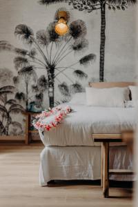 a bedroom with a bed with a table and palm trees at Hôtel PALMITO in Biarritz