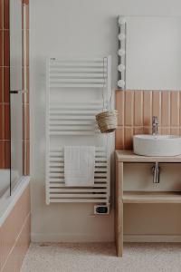 a bathroom with a sink and a shower with a towel at Hôtel PALMITO in Biarritz
