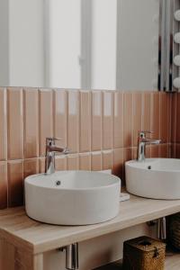 a bathroom with two sinks on a wooden counter at Hôtel PALMITO in Biarritz