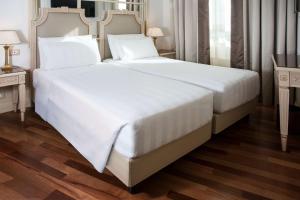 uma grande cama branca num quarto de hotel em Radisson Blu GHR Rome em Roma