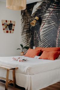 a bedroom with a white bed with red pillows at Hôtel PALMITO in Biarritz