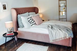 a pink bed with pillows on it in a bedroom at Apartment Aussee- Atelier Salzherrenhof- Küche, WLAN, Netflix in Bad Aussee