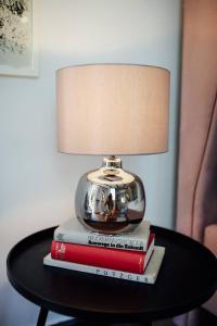 a lamp sitting on top of books on a table at Apartment Aussee- Atelier Salzherrenhof- Küche, WLAN, Netflix in Bad Aussee