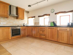 a large kitchen with wooden cabinets and appliances at Ingleborough Barn in Lancaster