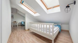 a white crib in a room with a skylight at 5D Apartament przy Plaży in Grzybowo