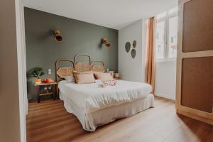 a bedroom with a large bed with white sheets at Hôtel PALMITO in Biarritz