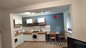 a kitchen with white cabinets and a table in it at Apartament w Centrum Cichy Zakątek in Gliwice
