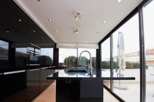 une cuisine avec des armoires noires et une grande fenêtre dans l'établissement Appartement privé vue mer Cannes centre Gray d'Albion, à Cannes